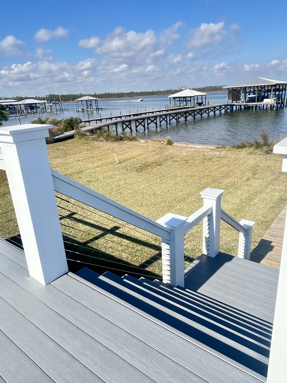 Cable railing following deck stairs down toward the water