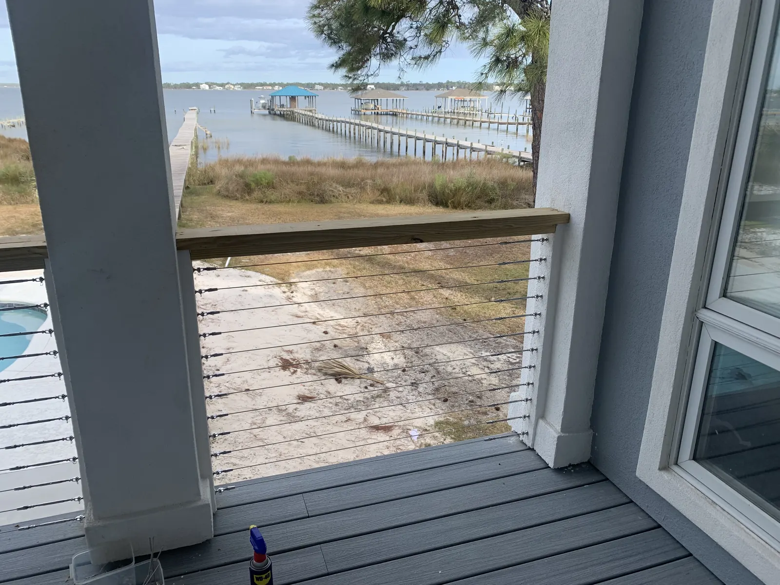 Cable railing running between white wood posts on a porch