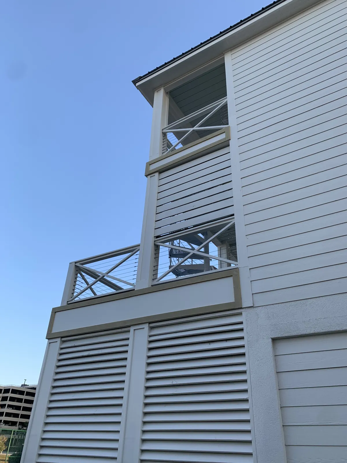 Upper porch with white X-pattern frames and stainless cable infill