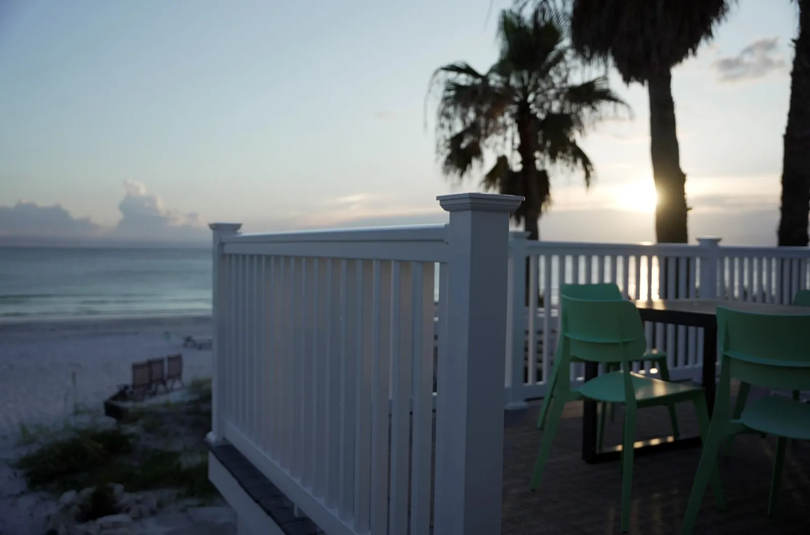 White vinyl railing on a beachfront deck at sunset