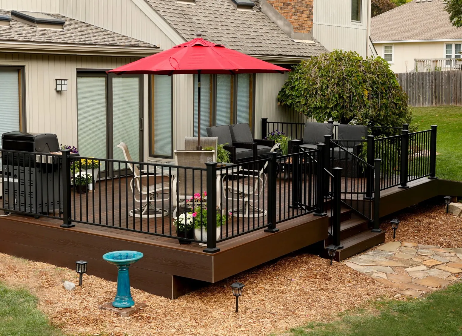 Dark composite deck with black steel railing and an umbrella