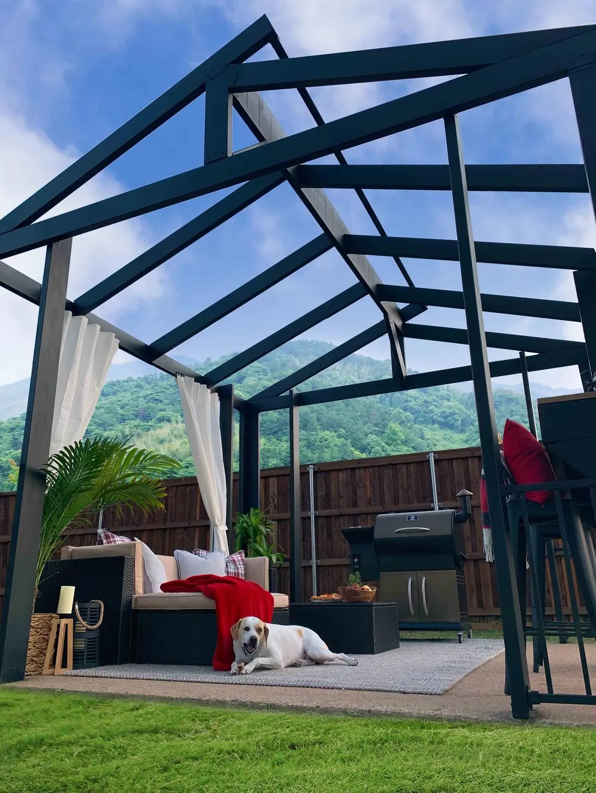 Gabled Fortress steel pergola with curtains over a patio