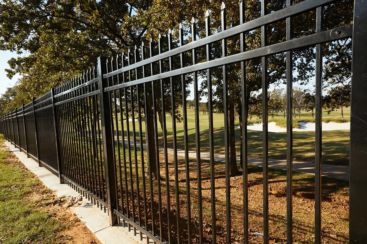 Fortress Versai steel fence along a tree-lined lot