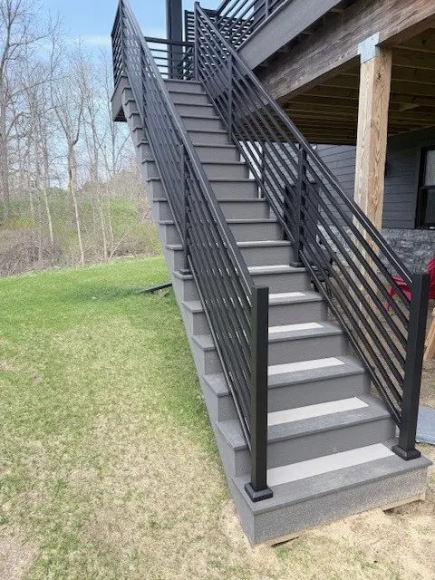 Long exterior staircase with black horizontal picket railing