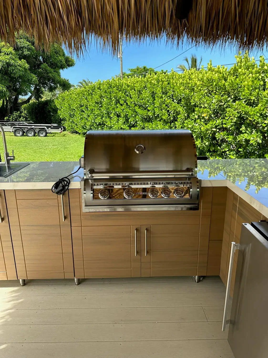 Woodgrain WeatherStrong kitchen with grill under a thatched roof