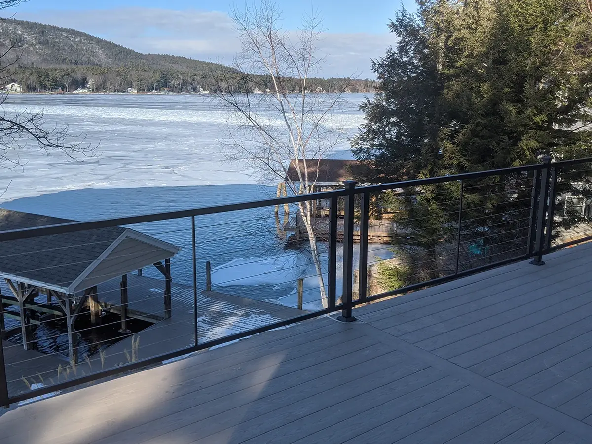 Black horizontal cable railing on a deck by the water