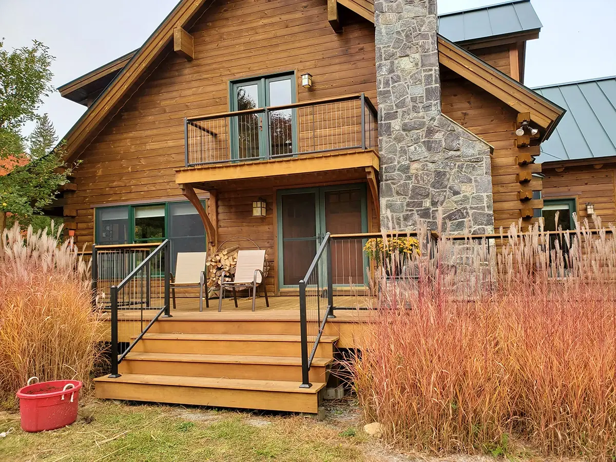 Horizontal stainless cable railing on a log-style home deck