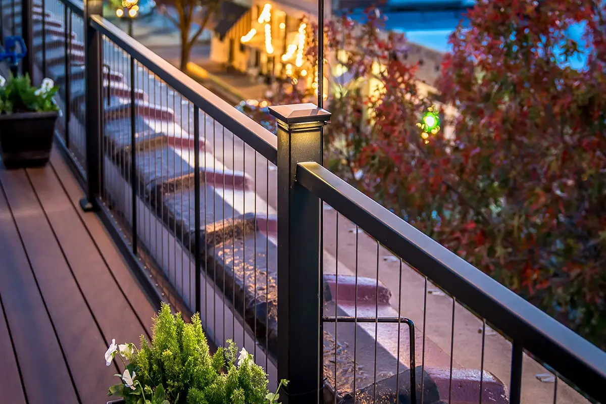 Black cable railing posts with fittings and wood cap rail