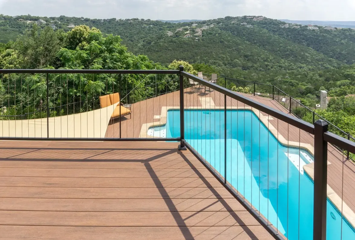 Stainless steel cable railing around a deck above a swimming pool