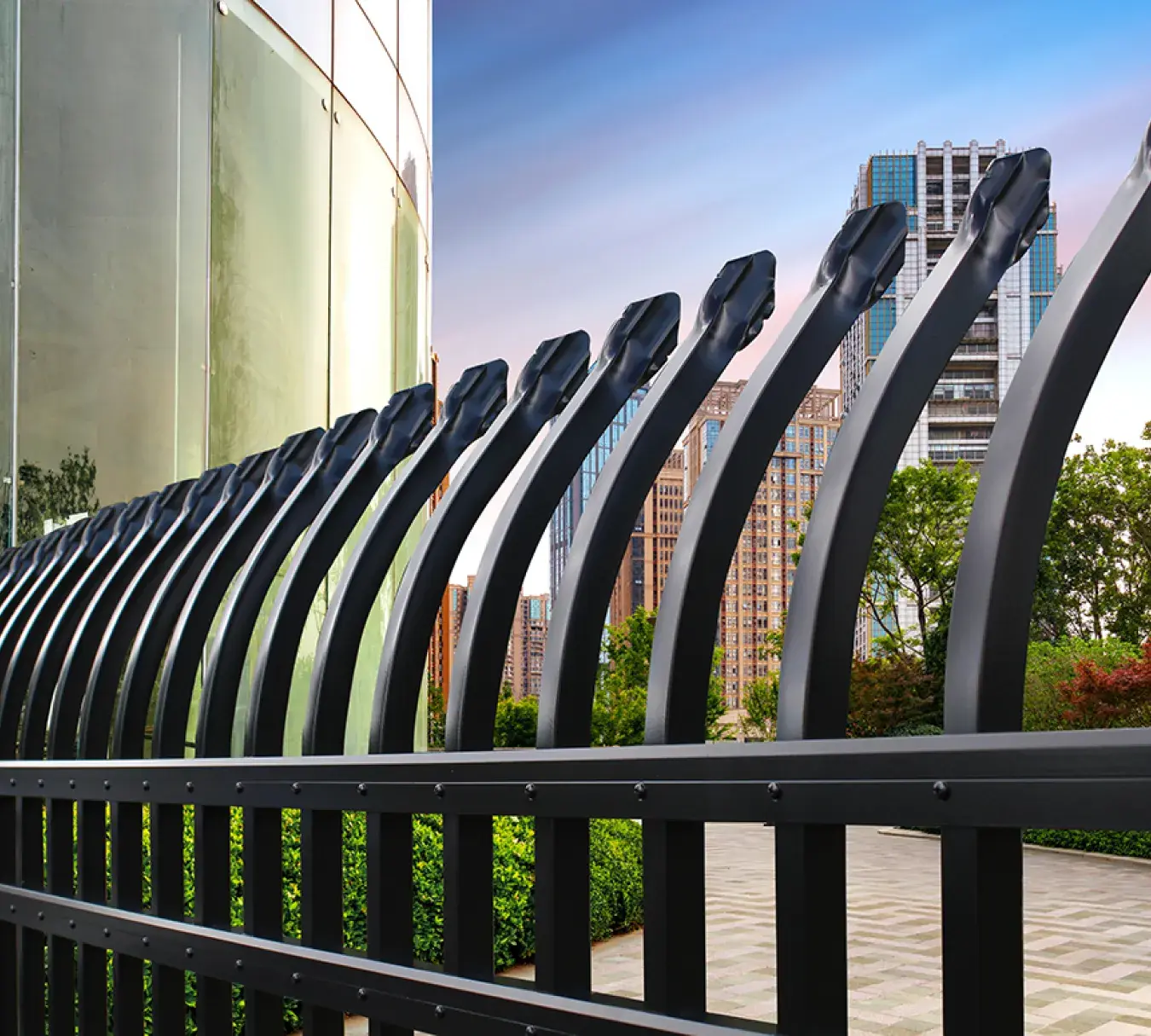 Catalyst security-style aluminum fence with curved pickets beside a city building