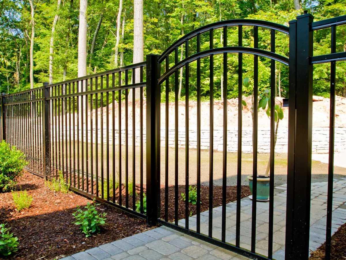 Catalyst arched black aluminum walk gate in a landscaped yard