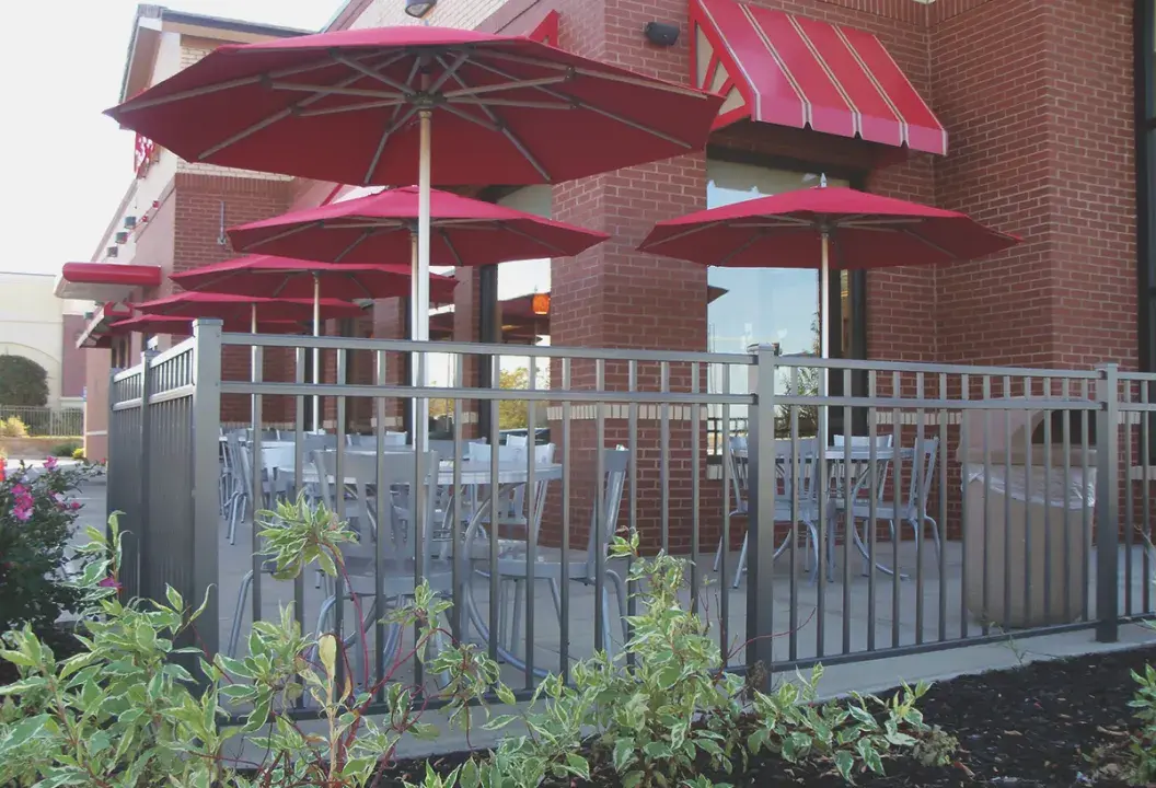 Catalyst metal picket fence enclosing a restaurant outdoor seating area