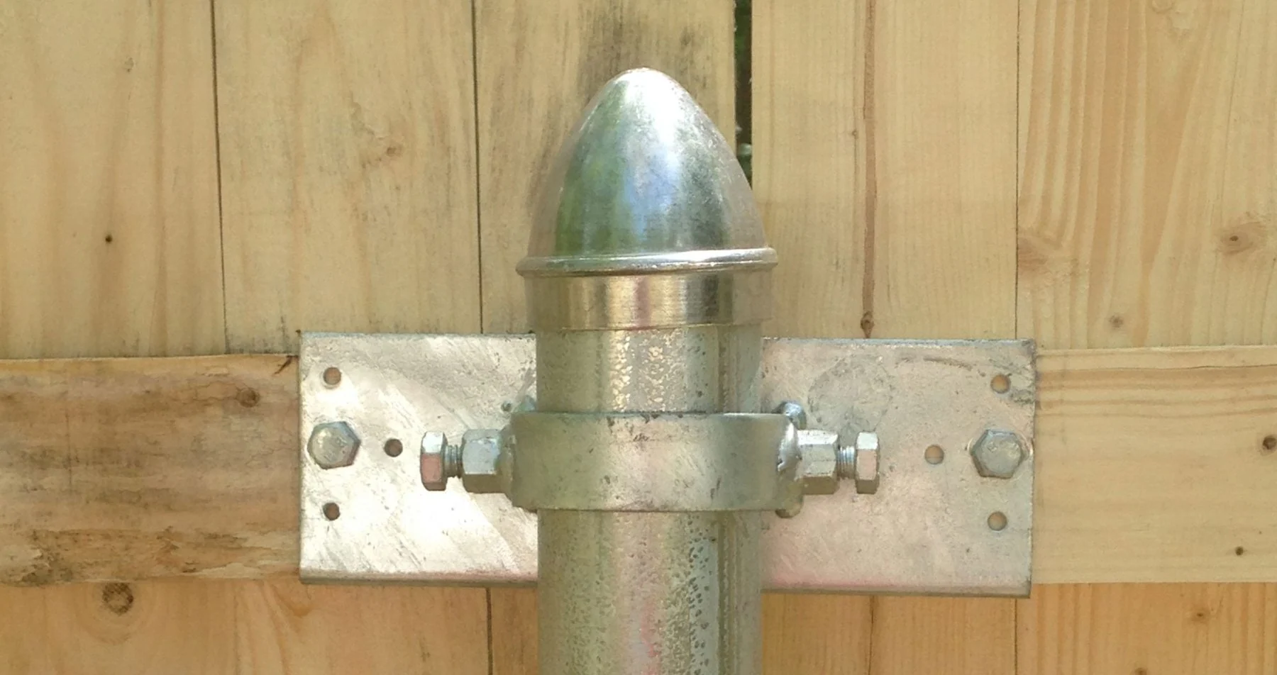 Galvanized gate post hardware on a cedar privacy gate