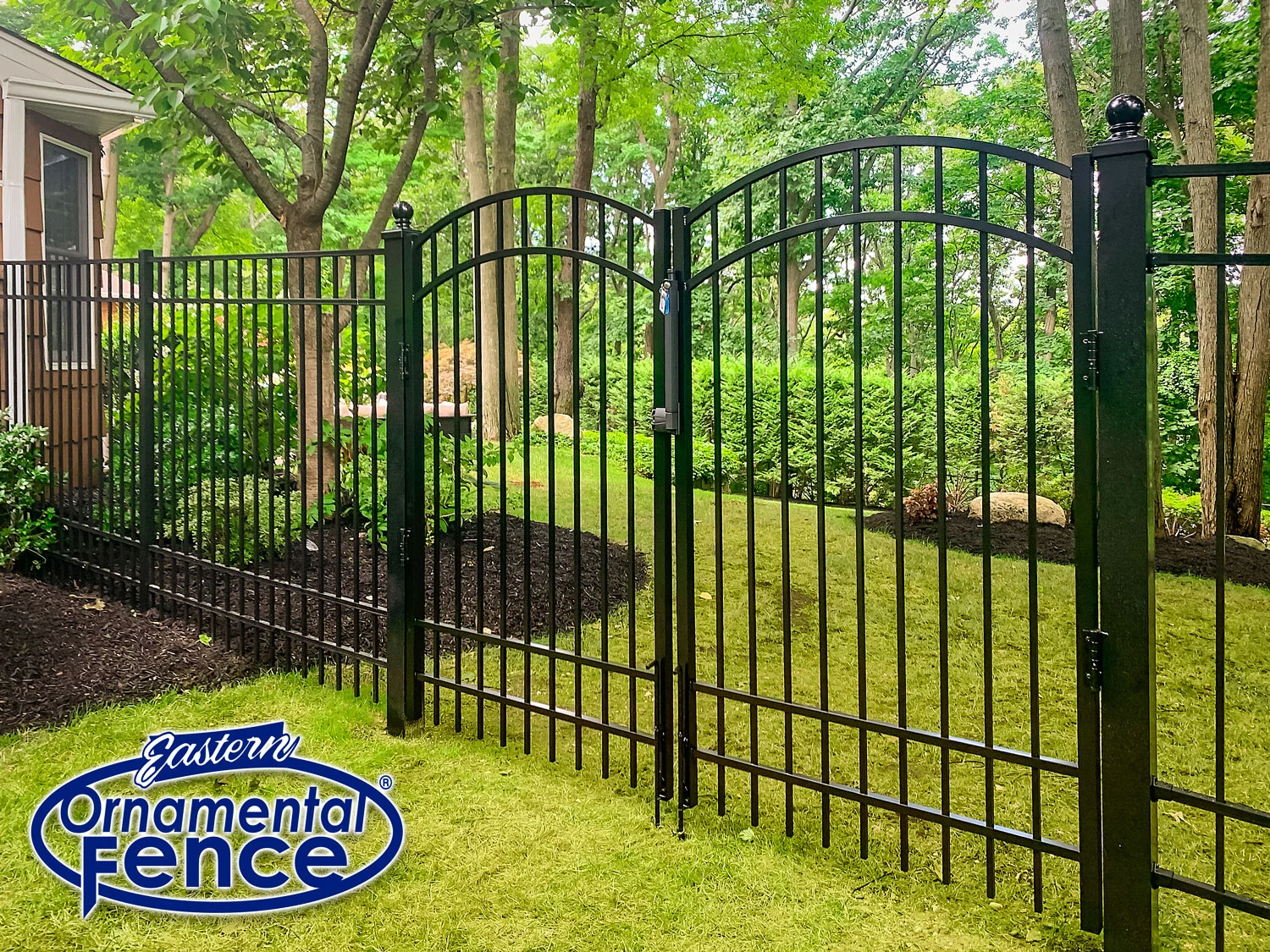 Eastern Ornamental arched gate in a black aluminum fence