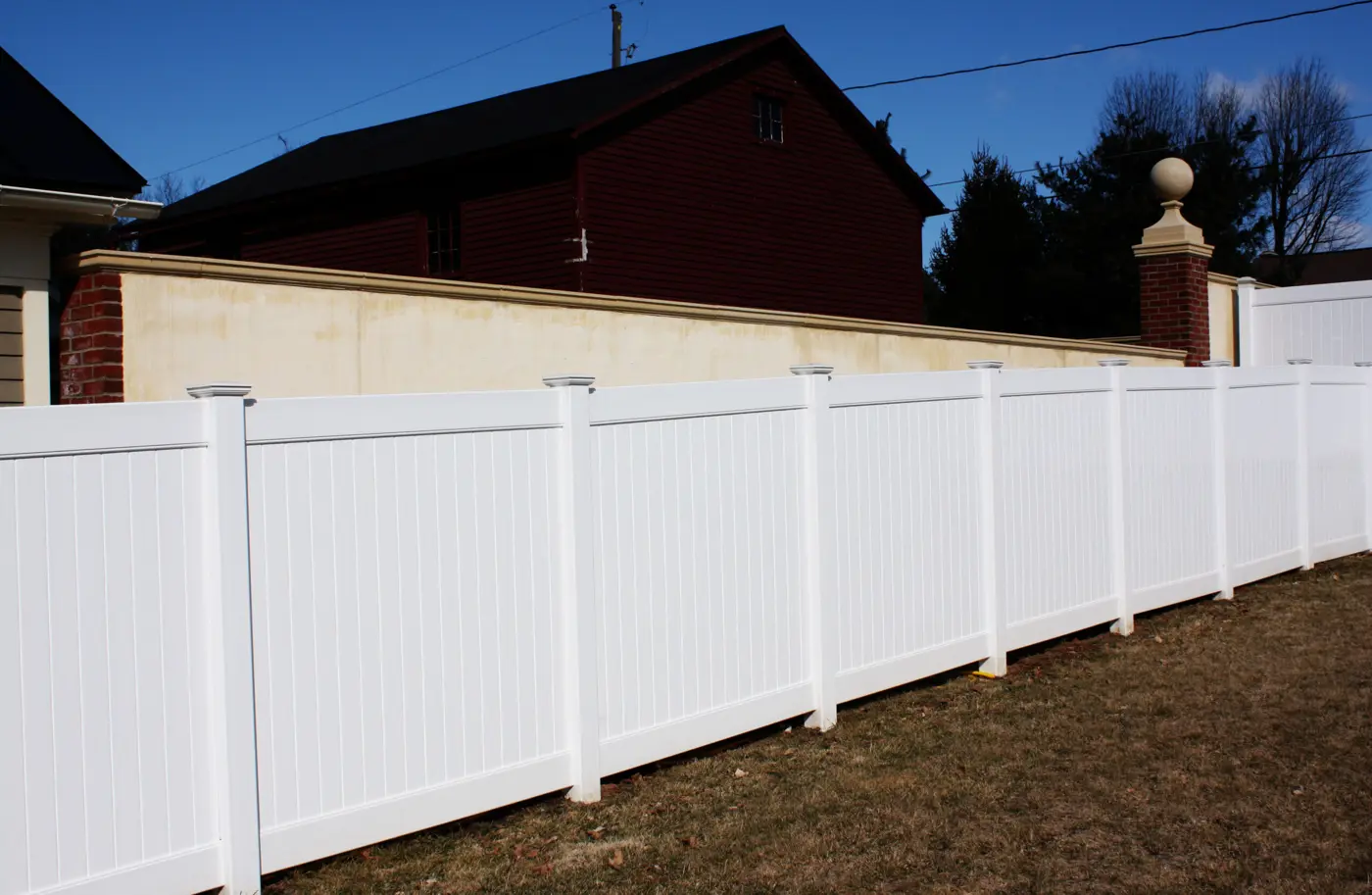 Envision white vinyl privacy fence beside a brick building
