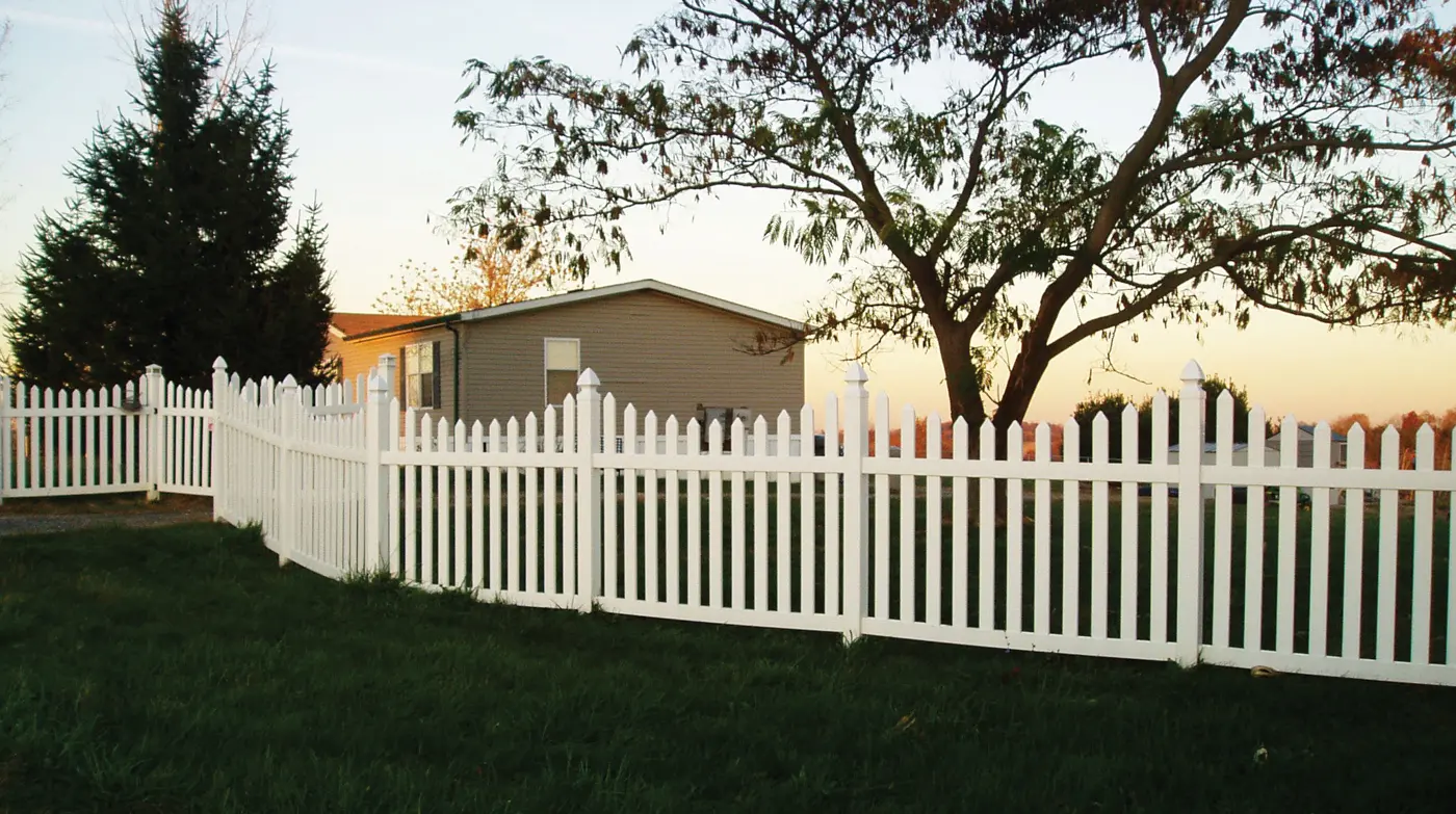 Envision white vinyl picket fence along a yard at dusk