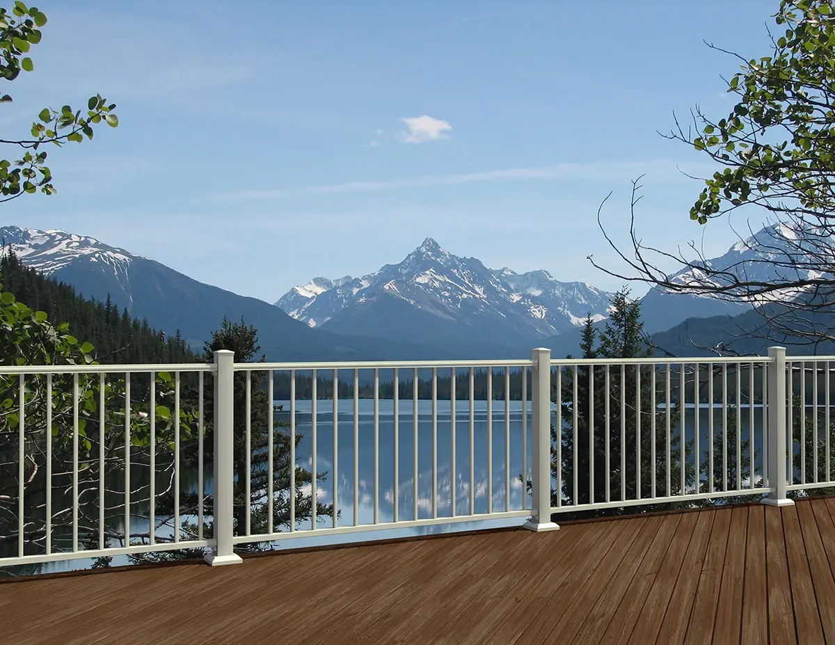 White railing on a deck facing snow-capped mountains