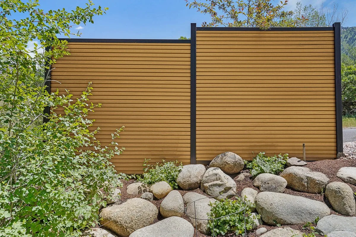 Riviera composite privacy fence panels in a warm teak color