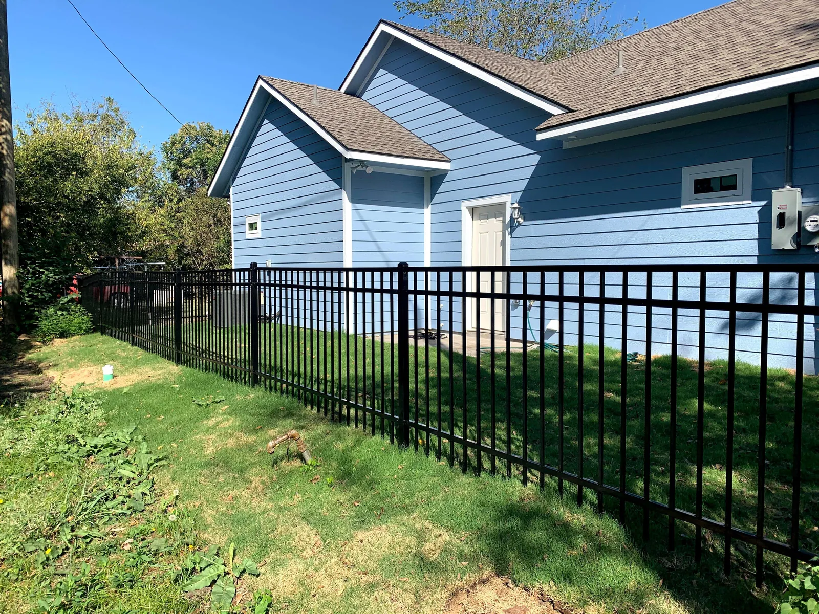 Black ornamental fence in a side yard