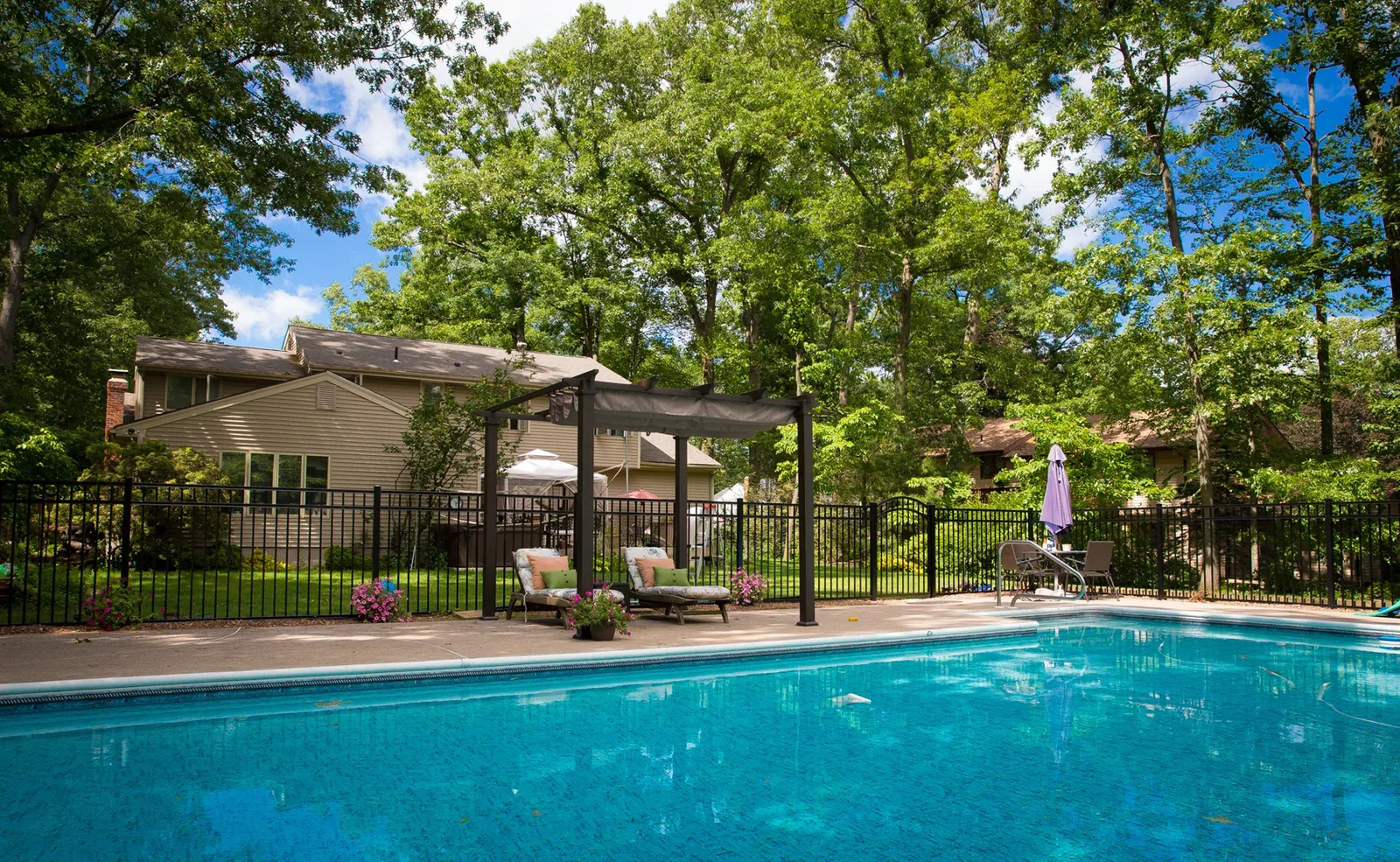 Aluminum pool fence with a shaded pergola