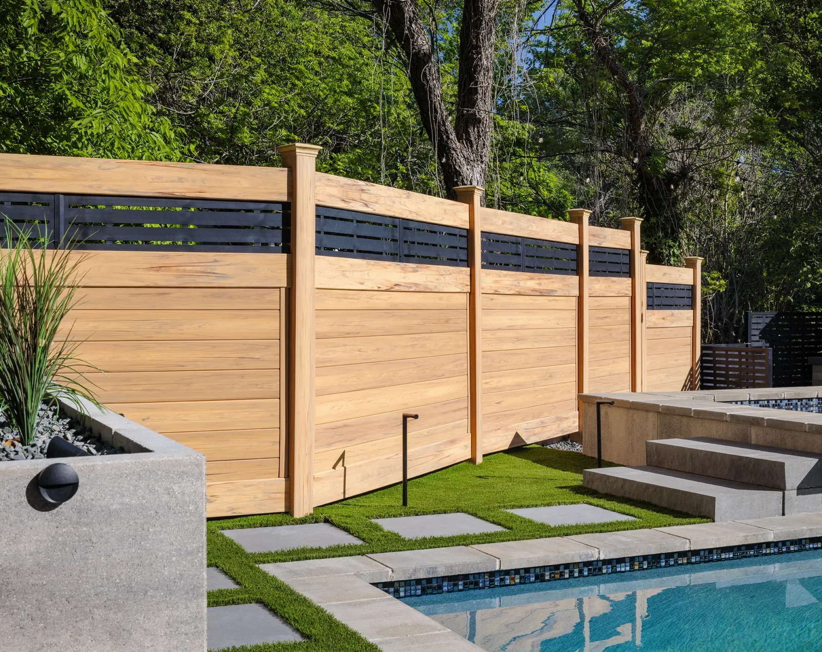 Wood-look privacy fence beside a pool