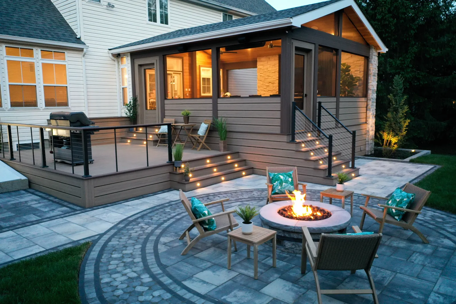 Deck stairs down to a paver patio and fire pit