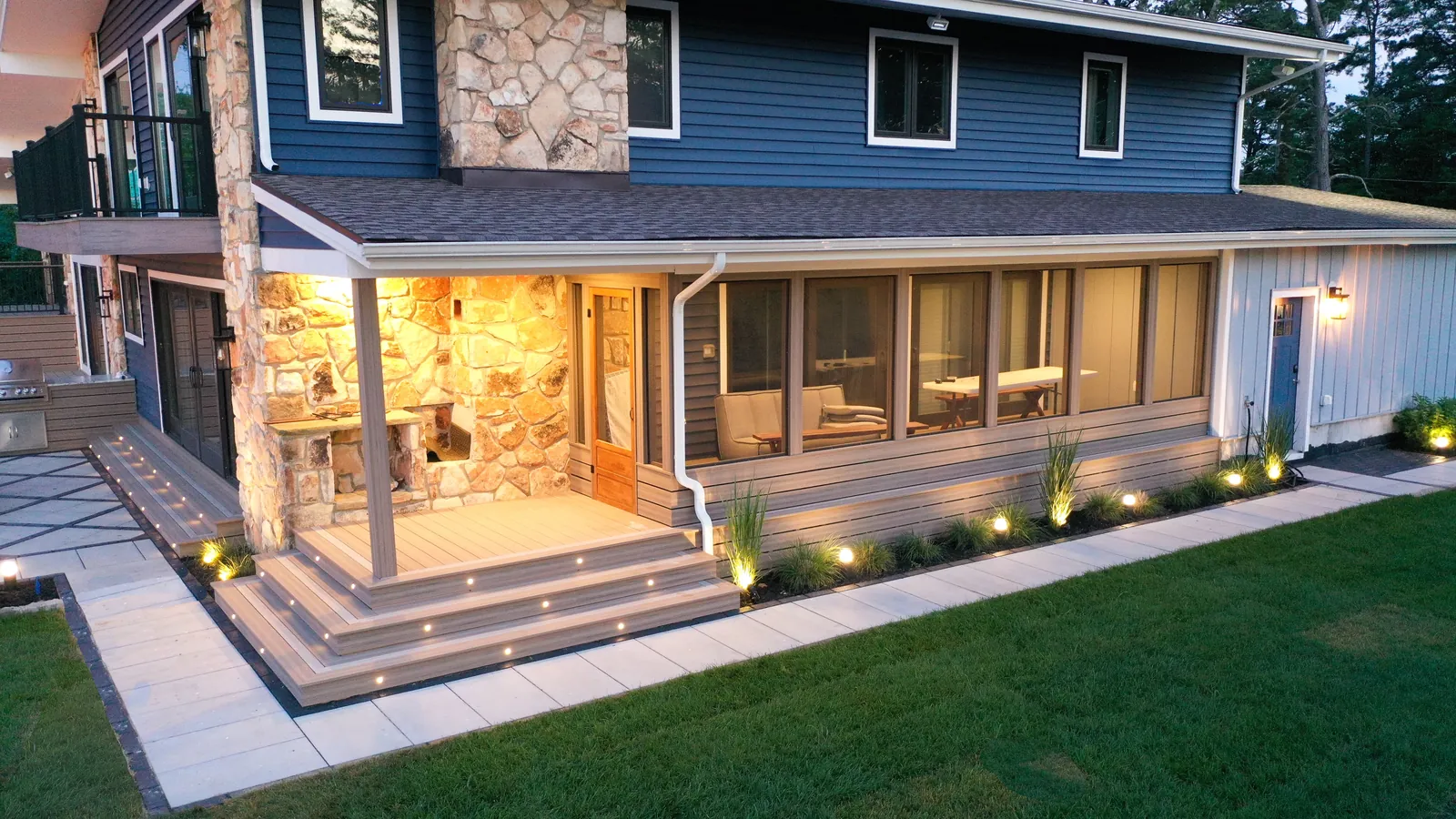 Screened porch deck with stair lights at dusk