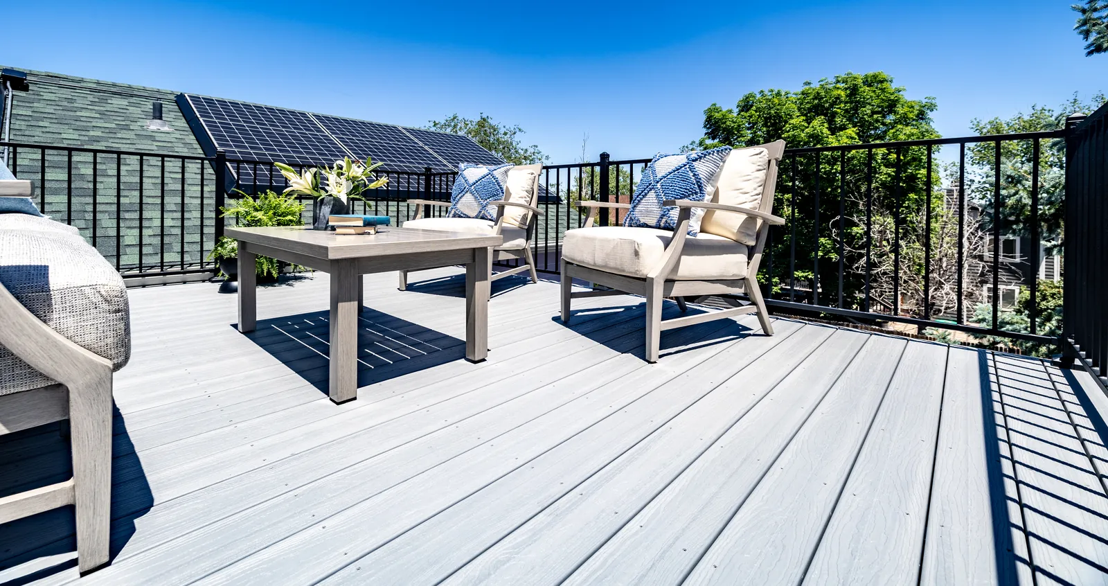Gray composite deck with black railing and patio chairs