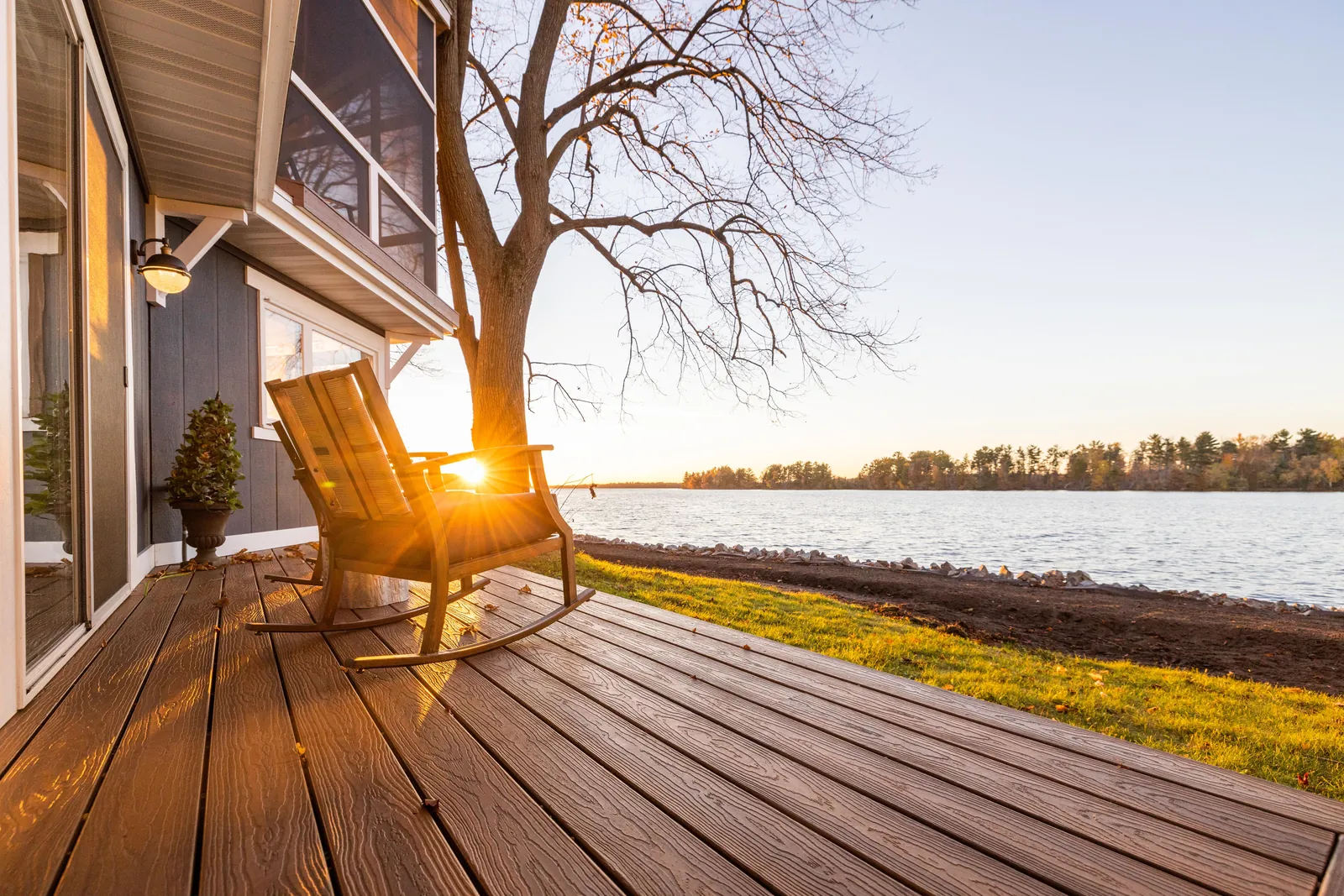 Lakeside deck with a rocking chair at sunrise