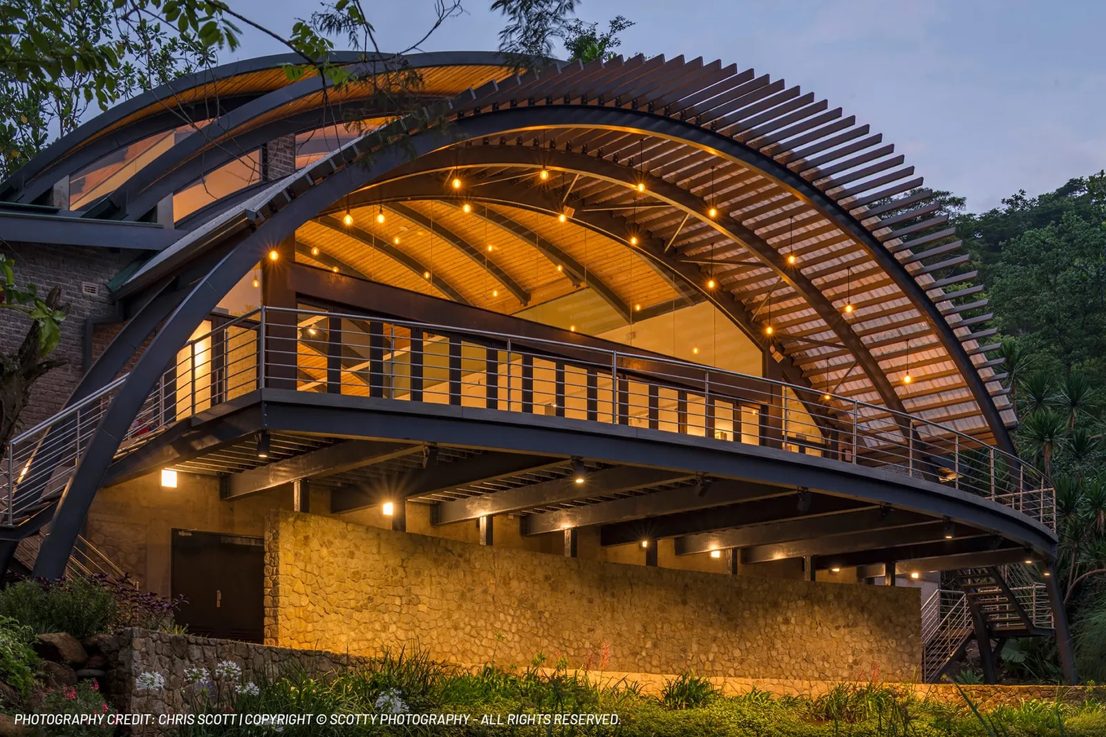Arched timber deck structure lit at dusk