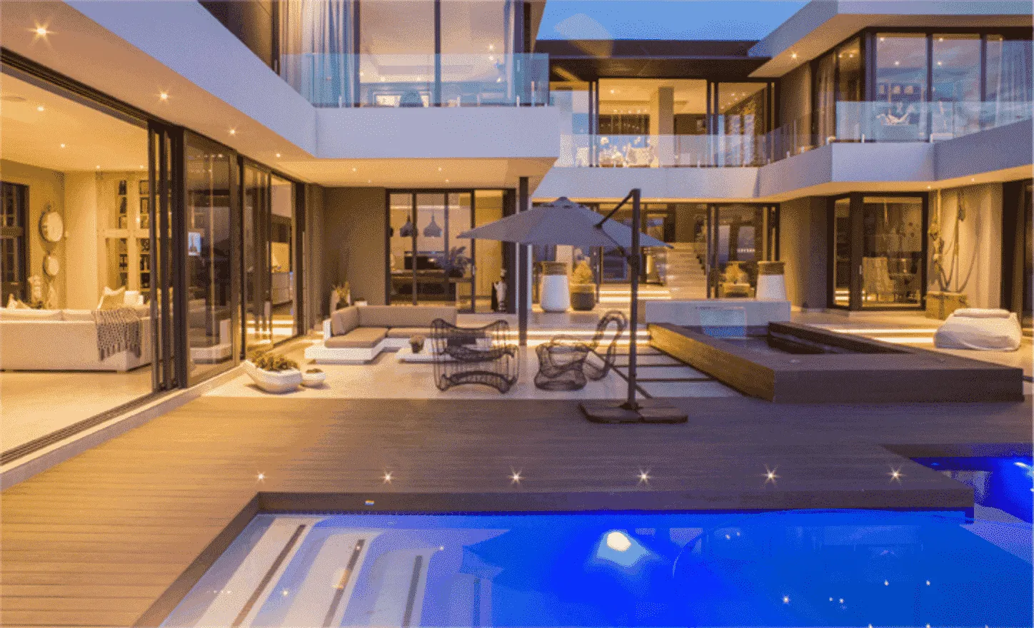 Modern pool deck and terraces lit up after dark