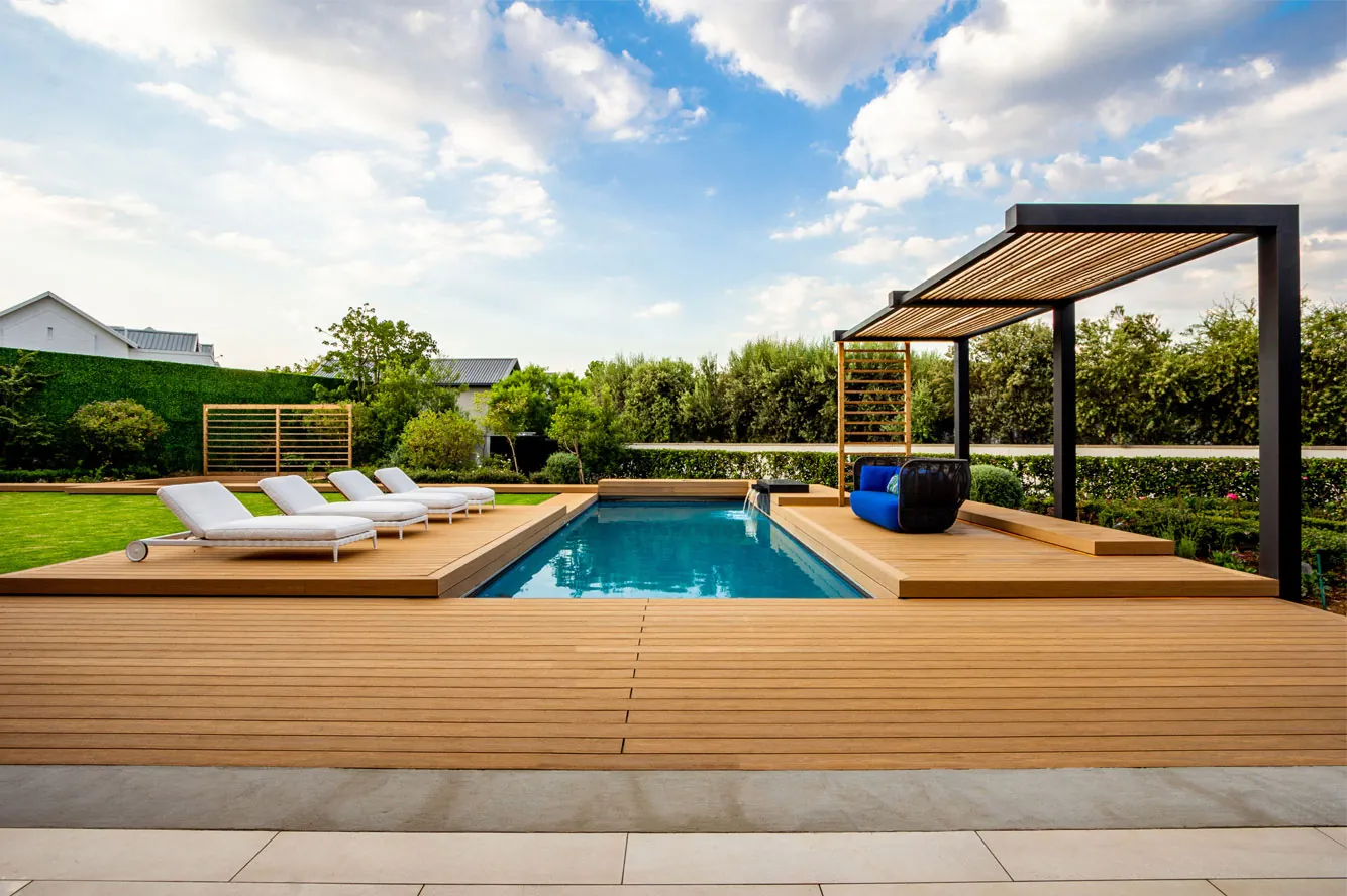 Pool deck with a shade structure and loungers