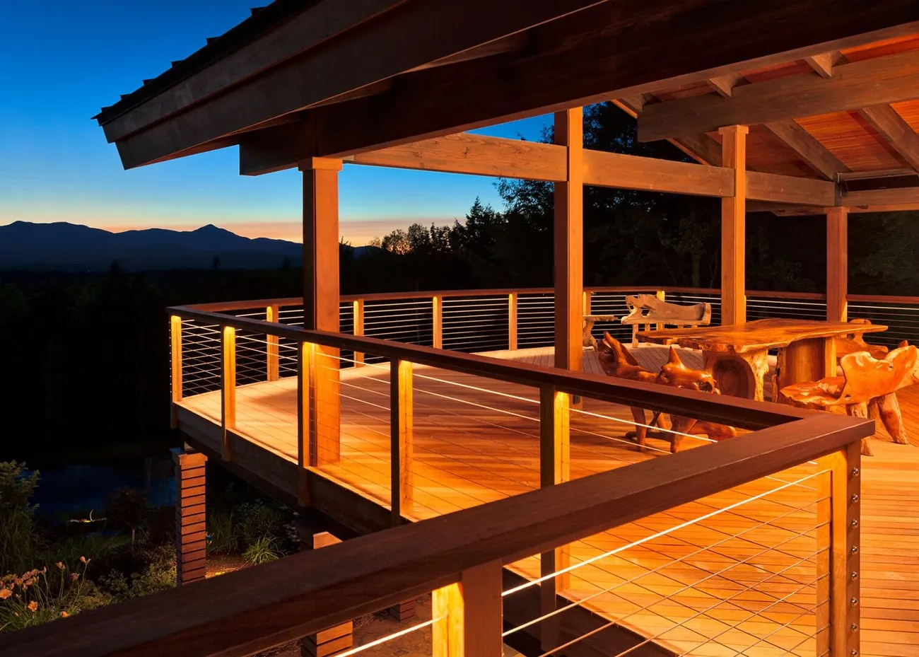 Covered deck with cable railing at dusk