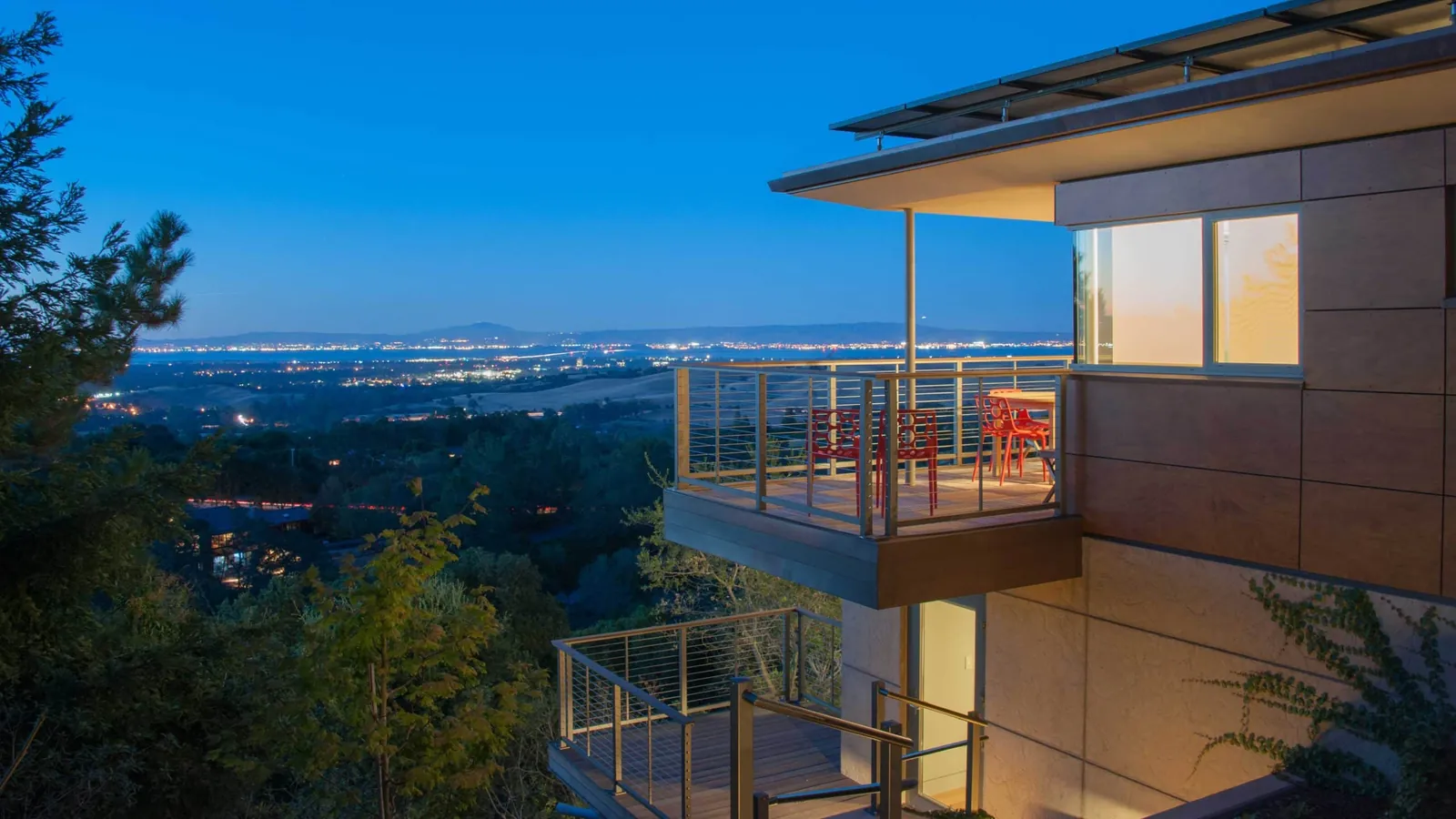 Modern home with cable railing balconies at dusk
