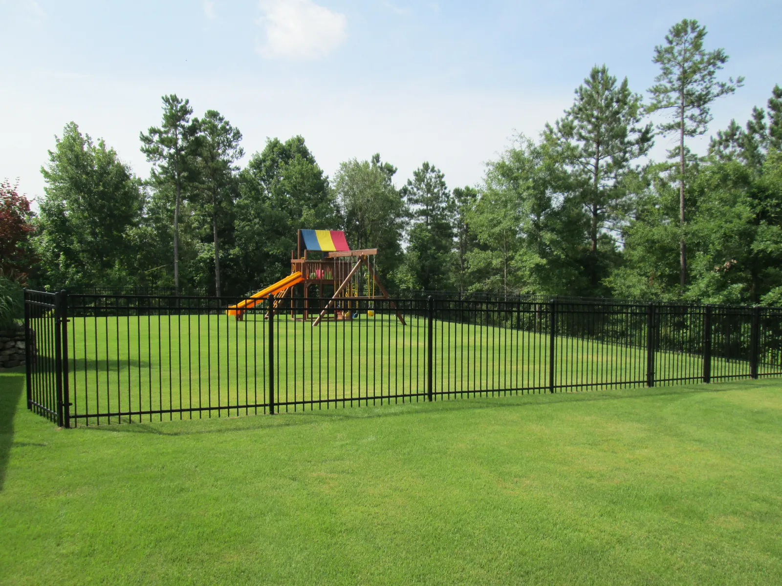 Black aluminum fence around a backyard