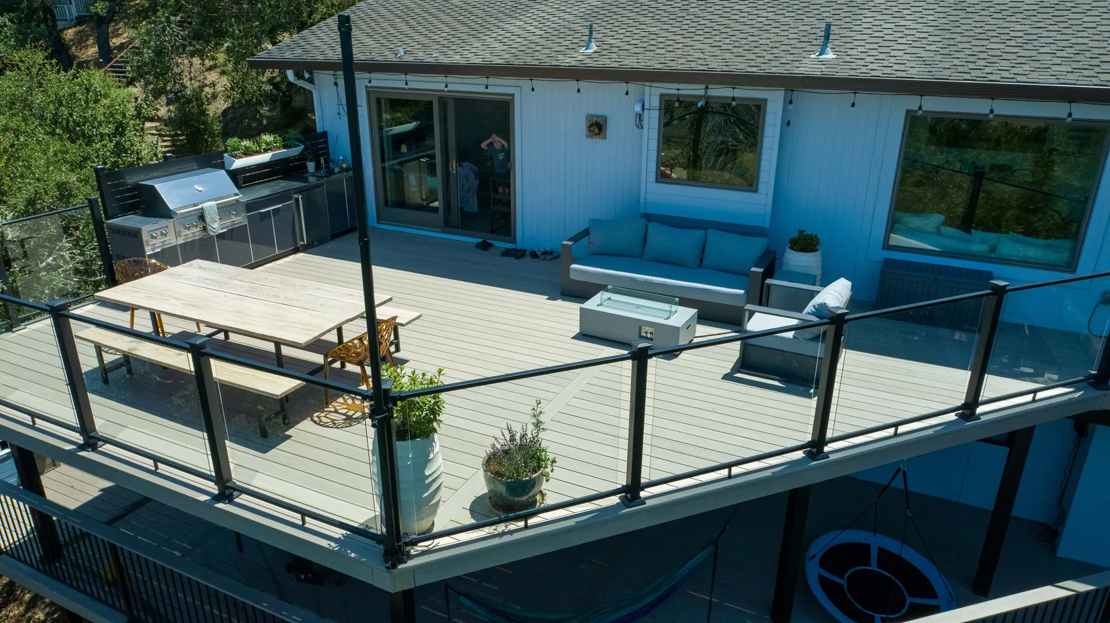 Elevated deck with grill, lounge seating and glass railing