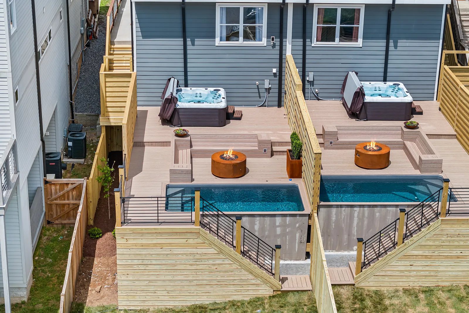 Aerial view of twin backyard decks with plunge pools and hot tubs