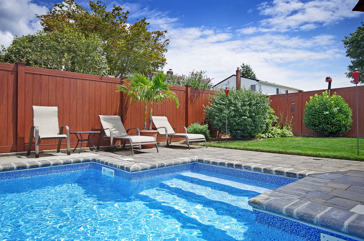 Red vinyl privacy fence around a pool