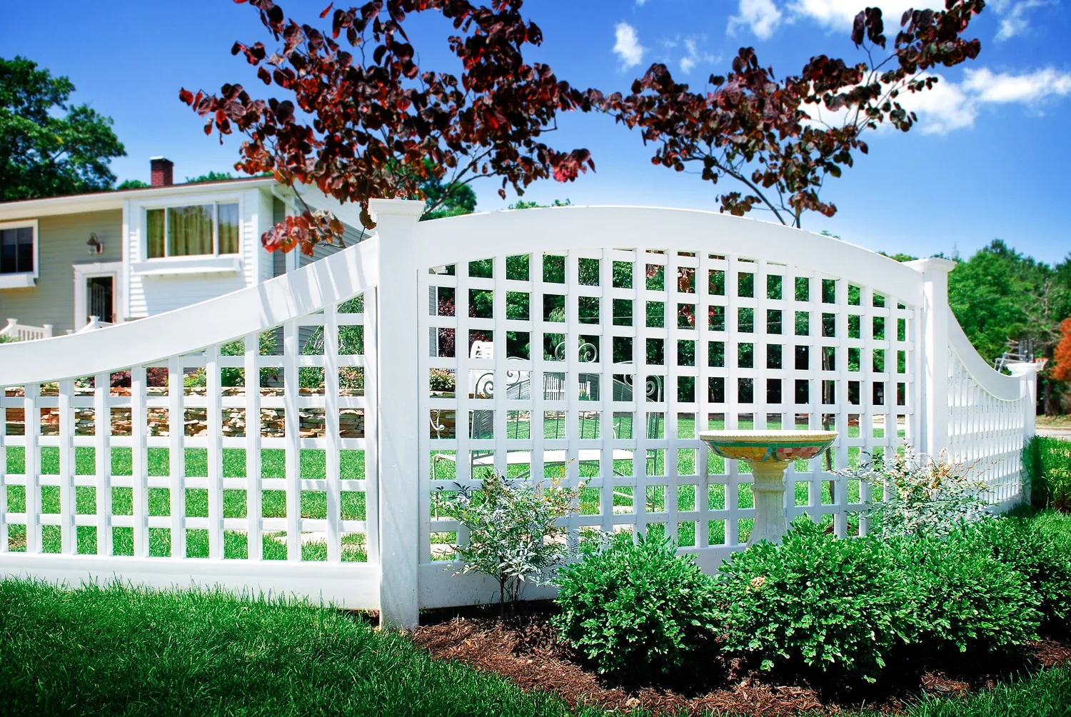 White vinyl lattice fence with flower beds