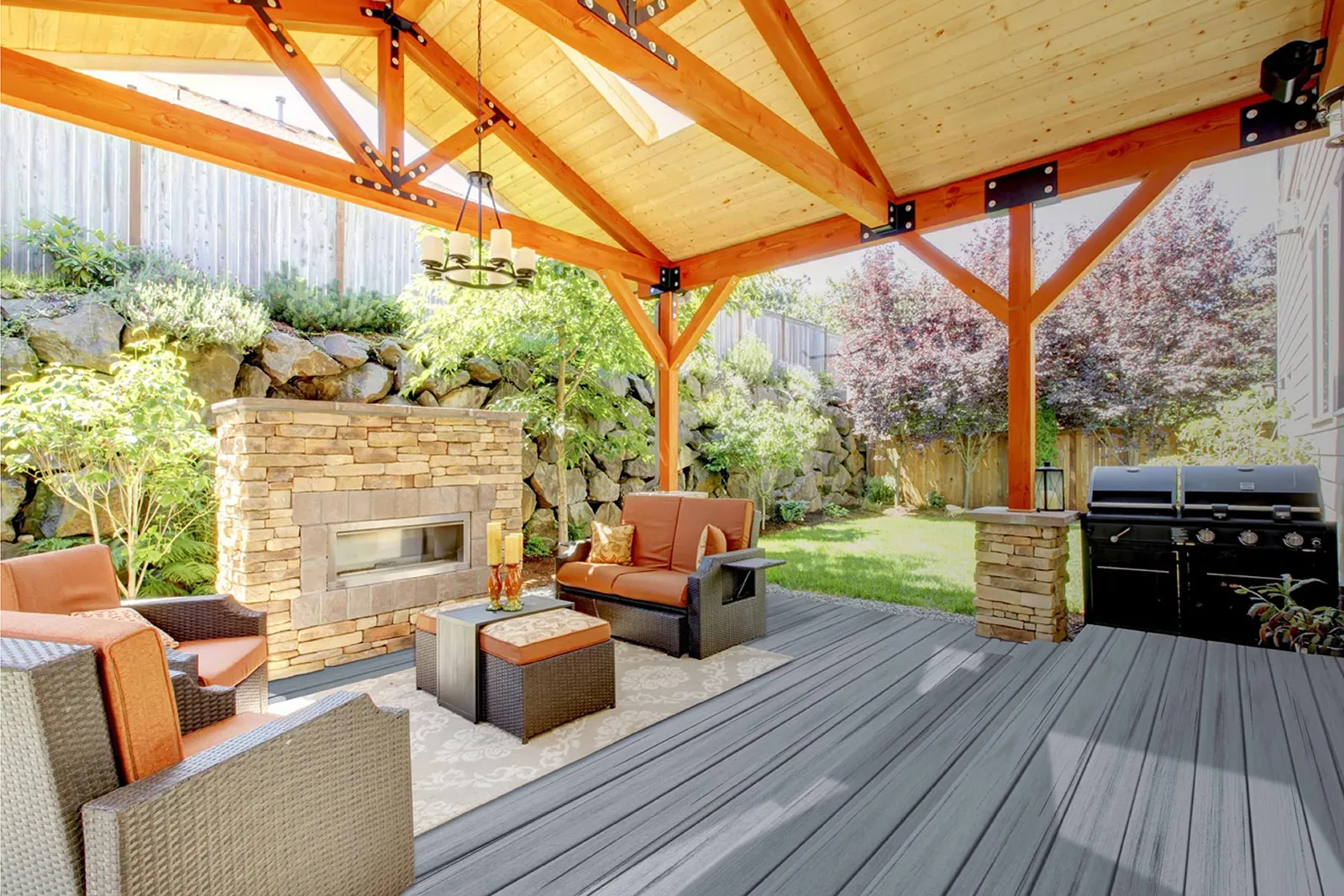Covered patio deck with a stone fireplace and outdoor living room