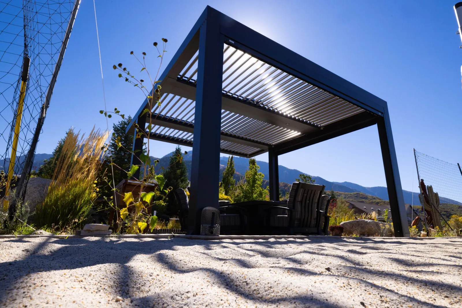Black louvered pergola in a mountain setting