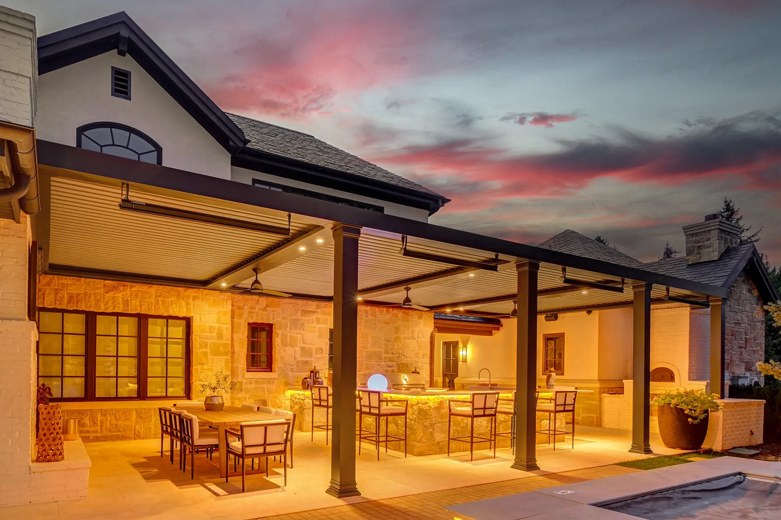 Covered patio with dining under a pergola at sunset