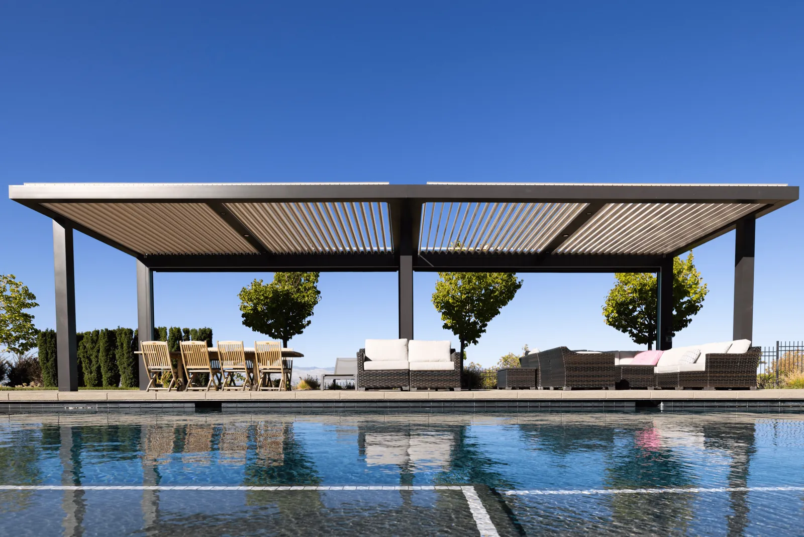 Louvered pergola cabana by a pool