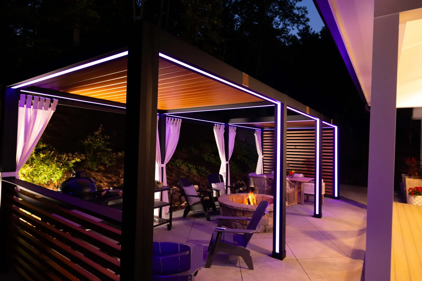 Pergola with curtains and accent lighting at night