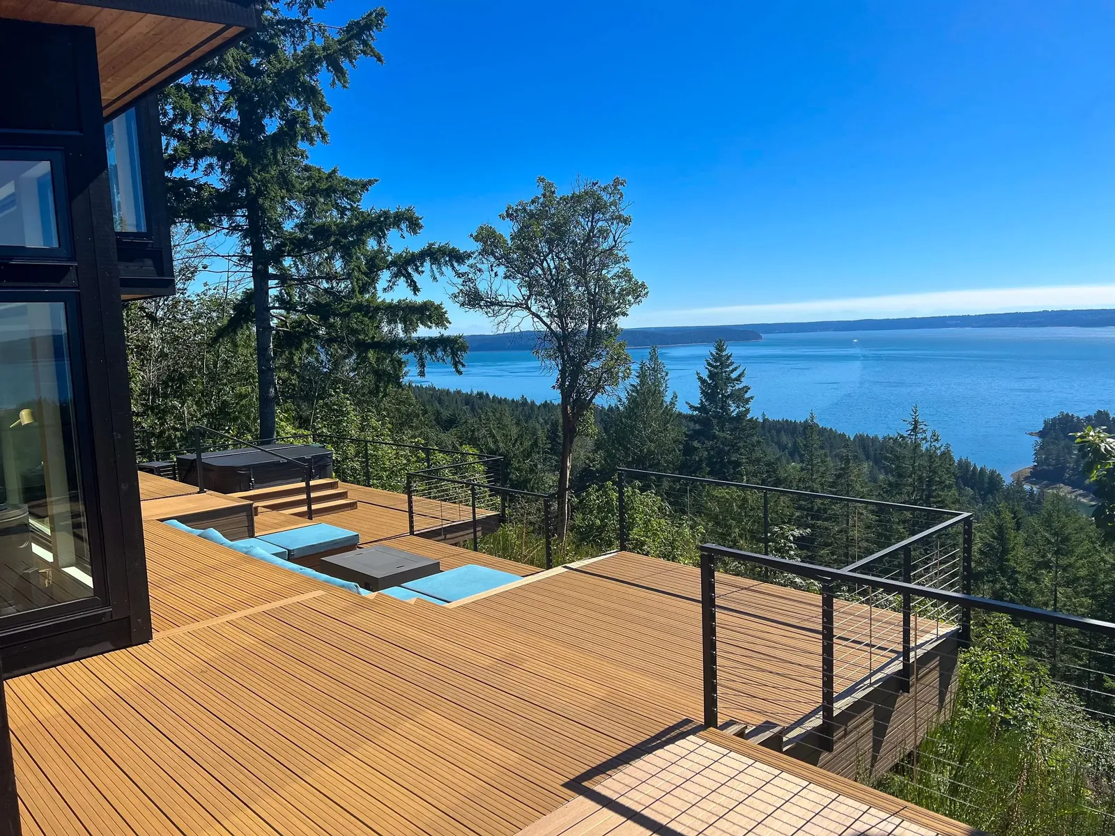 Deck with cable railing above a forest and bay