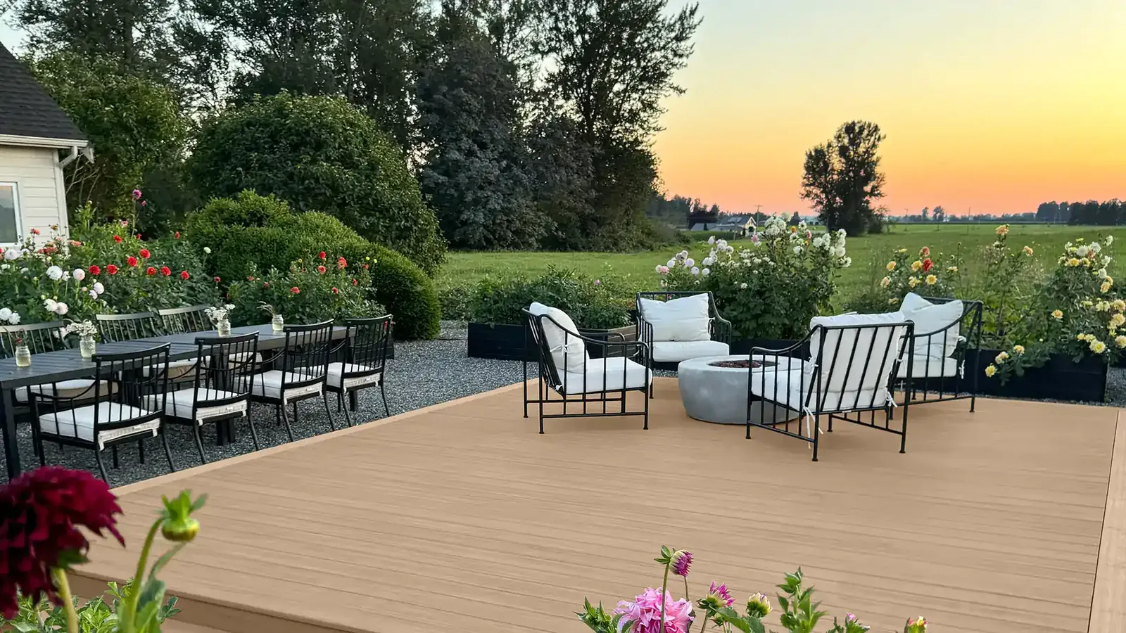 Composite deck with lounge chairs and gardens at sunset