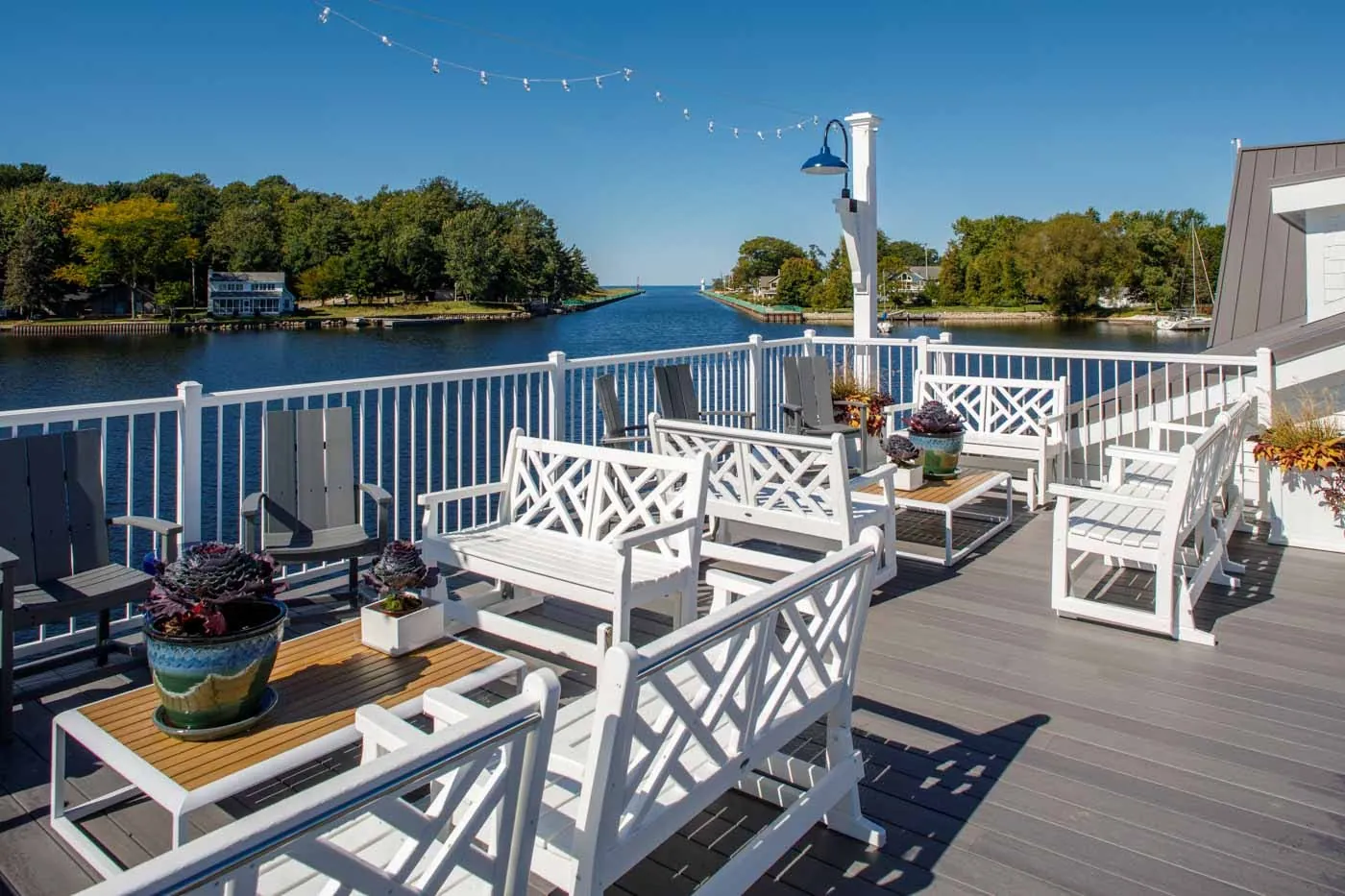 Lakeside deck with white railing and lounge seating