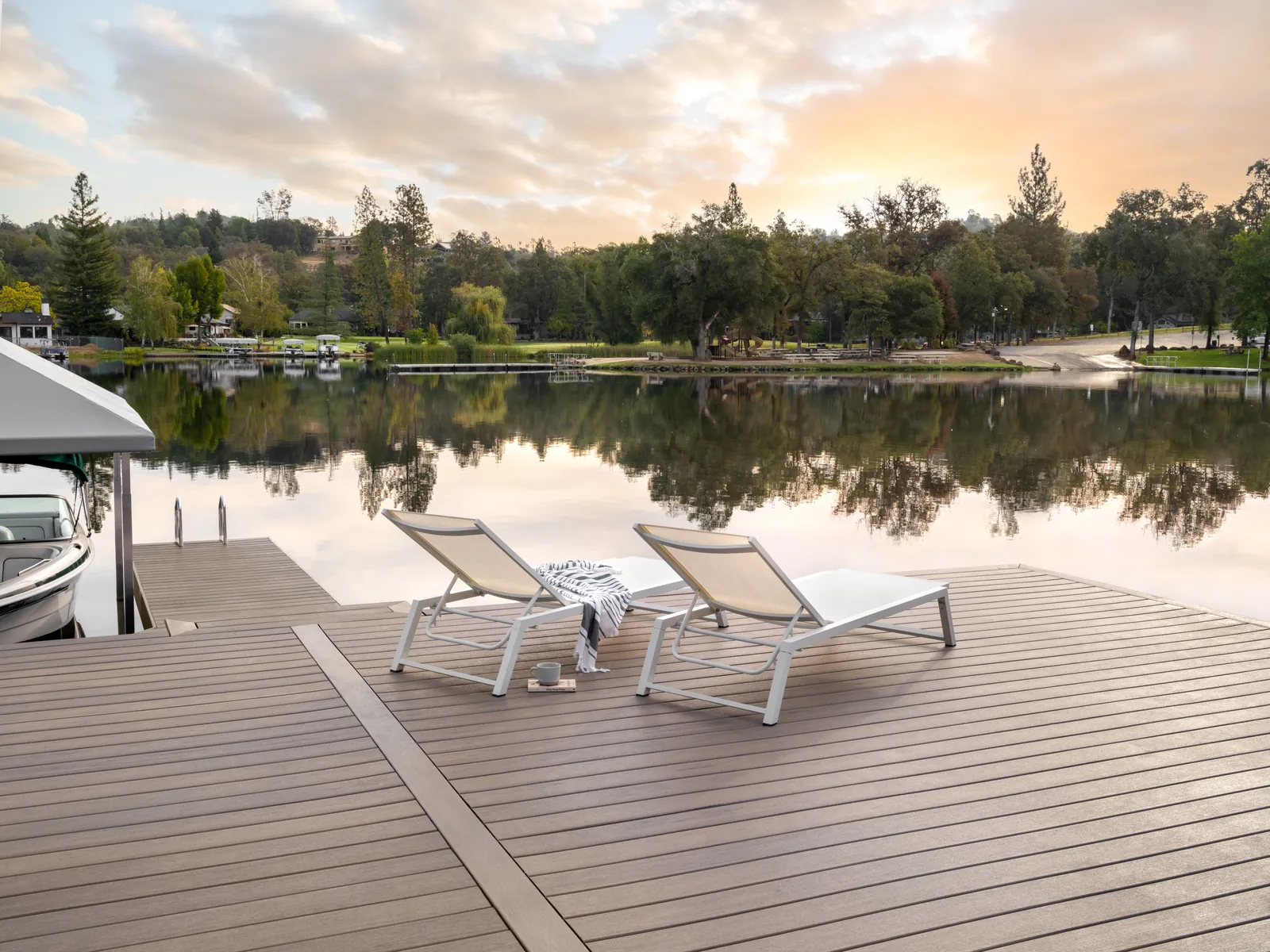 Lake dock deck with lounge chairs at sunrise