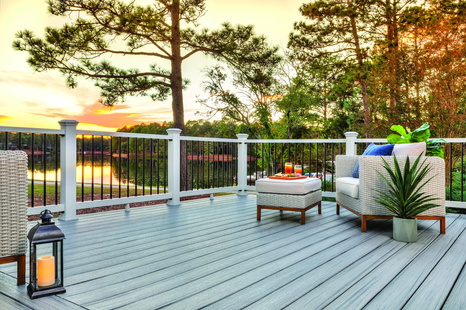 Light gray deck with white railing at sunset