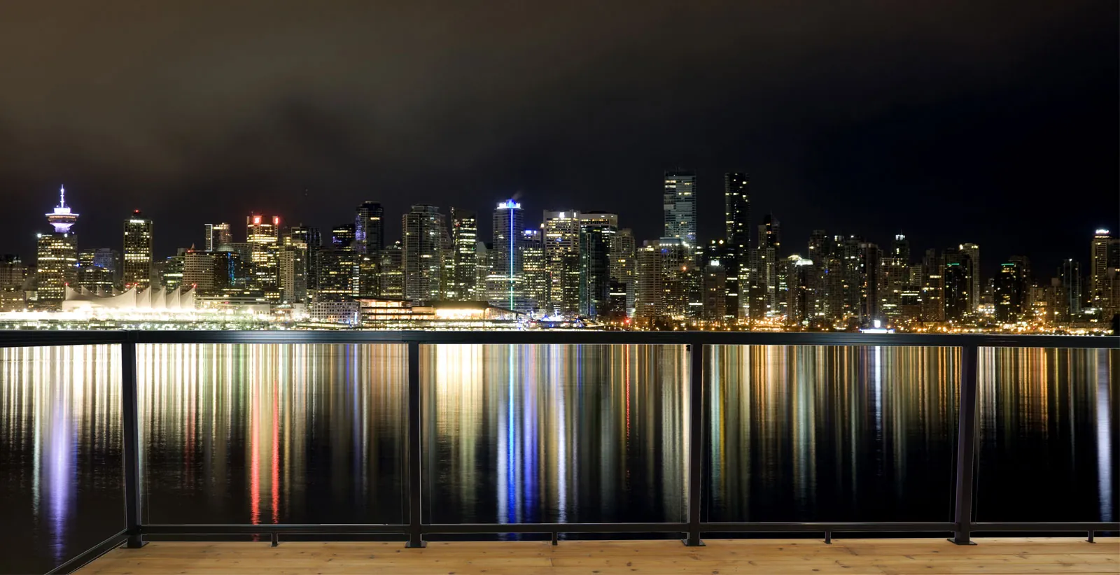 Glass railing on a waterfront promenade at night